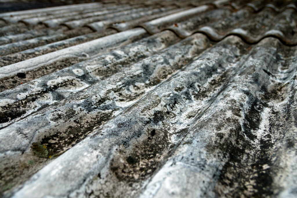 Close-up of ageing asbestos roof showing wear and damage.