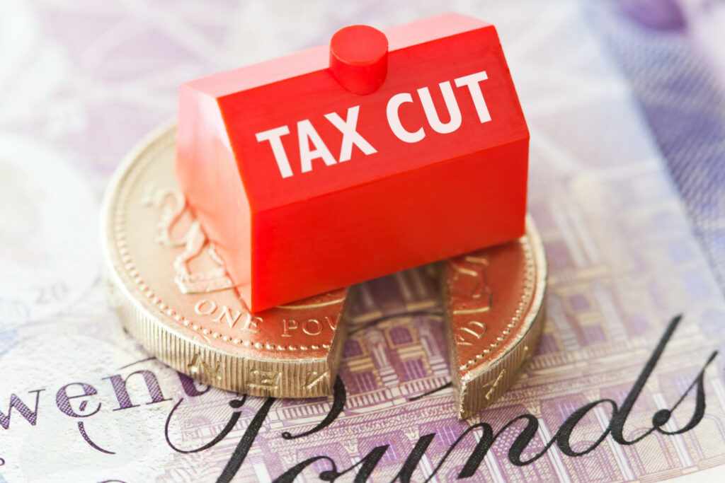 Pound coin and twenty-pound note with ‘tax cut’ block, representing corporation tax relief for asbestos roof works
