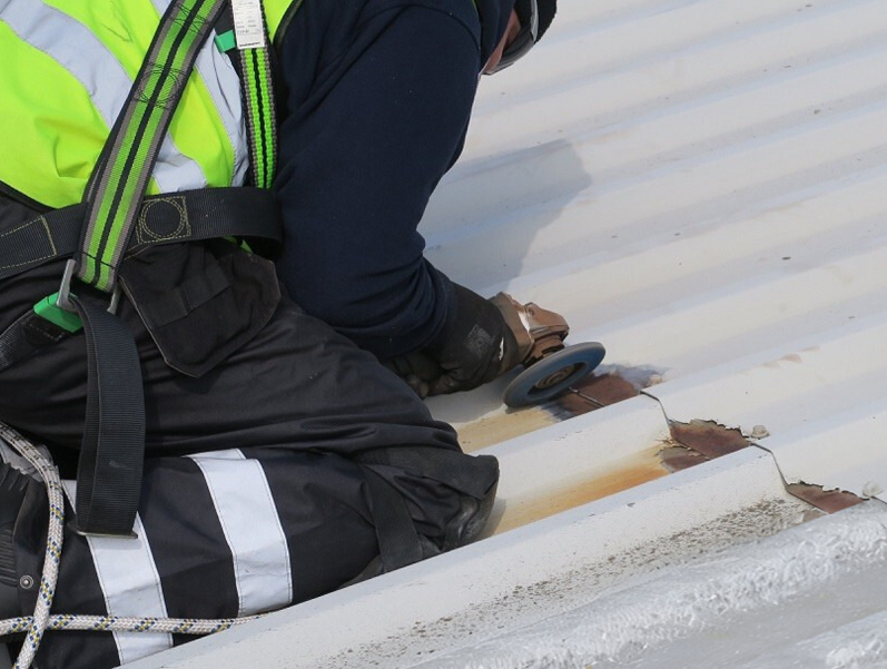 A person repairing cut edge corrosion.