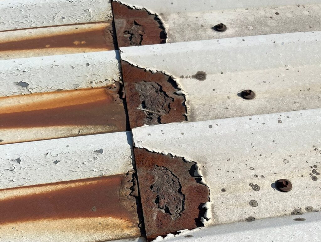 A metal roof with cut edge corrosion, with brown rust at the edges.